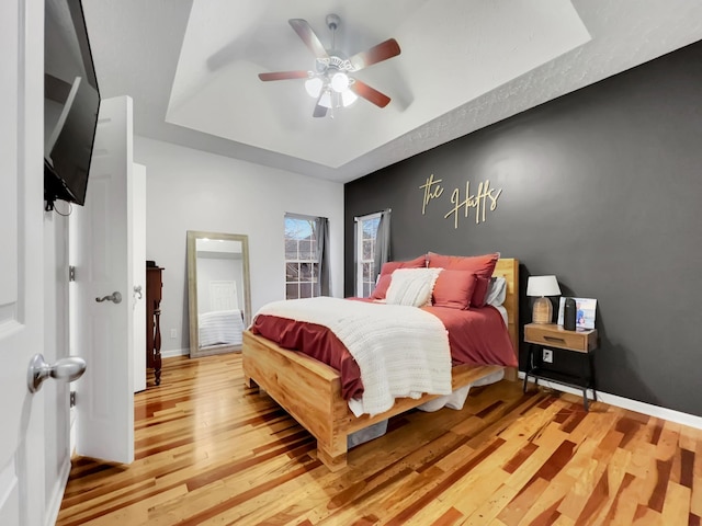 bedroom featuring light wood-type flooring, ceiling fan, and baseboards