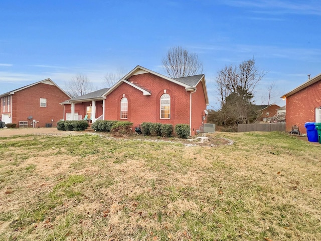 view of property exterior with a garage, a yard, fence, and brick siding