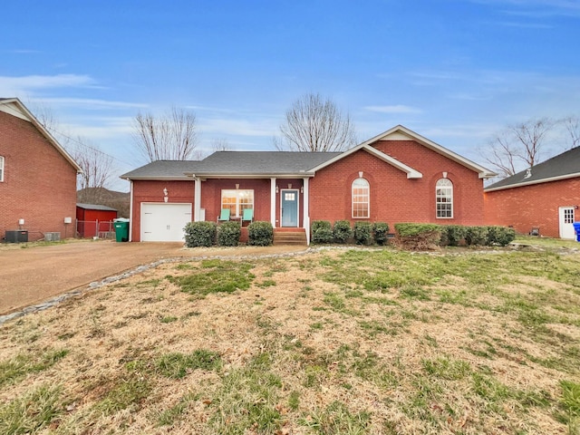 ranch-style home featuring an attached garage, driveway, central AC unit, and brick siding