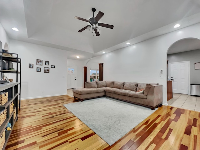 living area featuring light wood-type flooring, arched walkways, and recessed lighting