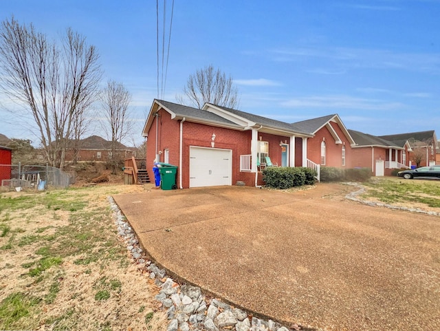 ranch-style home with a garage, covered porch, concrete driveway, and brick siding