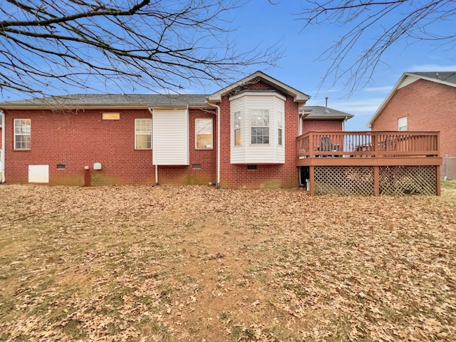 rear view of property featuring crawl space, brick siding, and a wooden deck