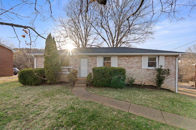 single story home with brick siding and a front yard