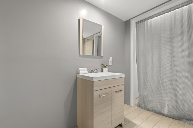 full bathroom featuring curtained shower, wood finish floors, and vanity