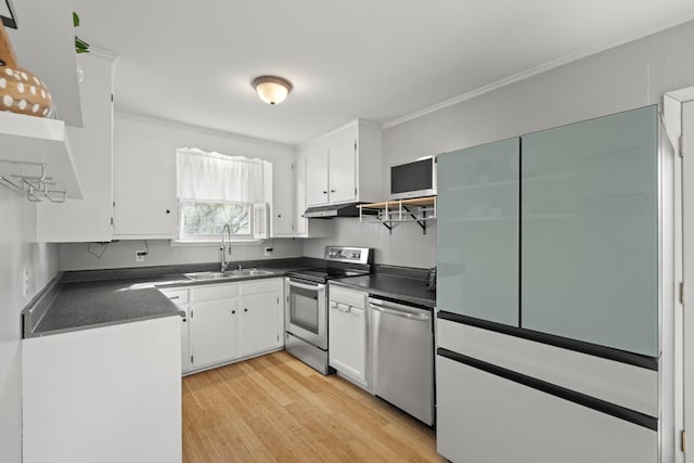 kitchen featuring appliances with stainless steel finishes, dark countertops, white cabinetry, and a sink