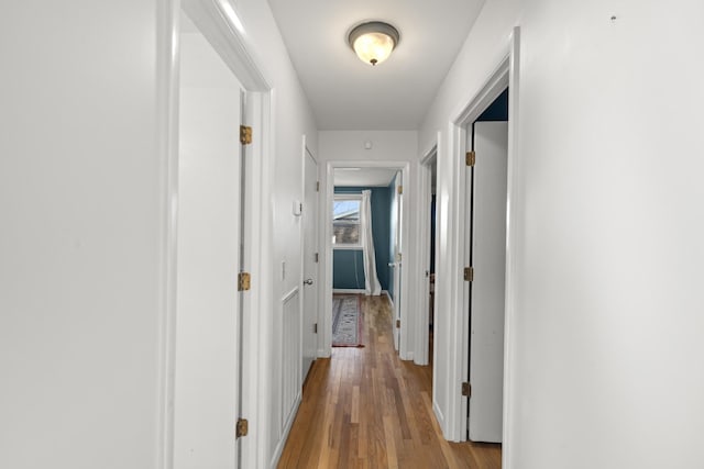 hallway featuring baseboards and wood finished floors