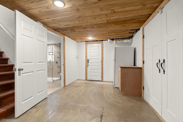 basement featuring wood ceiling, stairs, and freestanding refrigerator