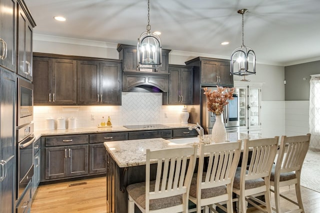 kitchen with light stone countertops, dark brown cabinets, stainless steel appliances, and crown molding