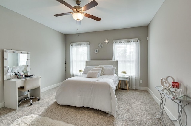 carpeted bedroom with multiple windows, baseboards, and a ceiling fan