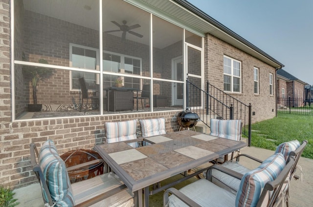 view of patio / terrace with a sunroom, fence, and outdoor dining area