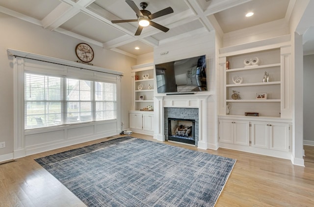 living room with light wood finished floors, a fireplace, coffered ceiling, and built in shelves