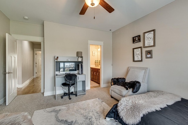 carpeted bedroom featuring a ceiling fan, baseboards, and ensuite bath