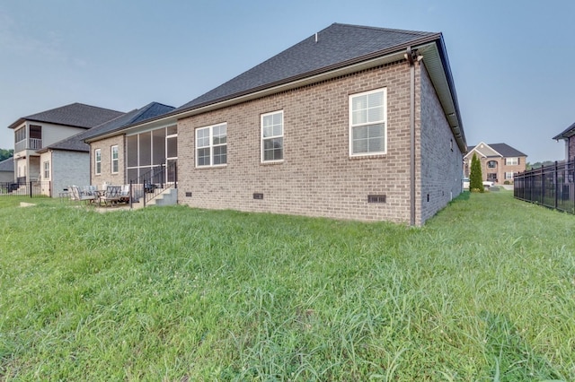 back of property featuring brick siding, fence, roof with shingles, crawl space, and a lawn