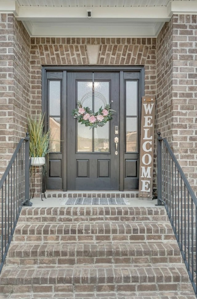 view of exterior entry with brick siding