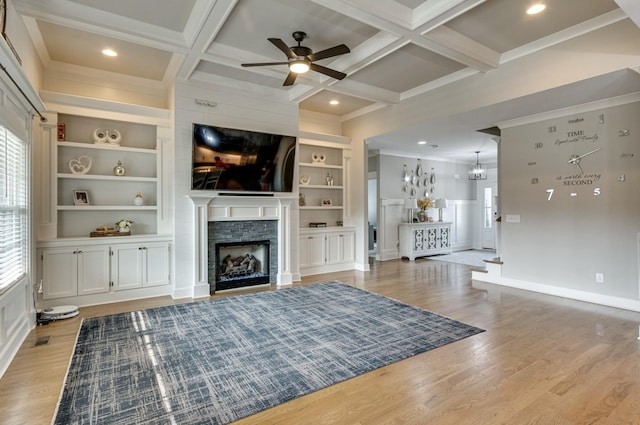 unfurnished living room with light wood-style floors, beam ceiling, coffered ceiling, and a fireplace