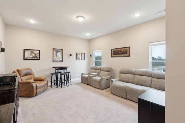 carpeted living area featuring baseboards, visible vents, and recessed lighting