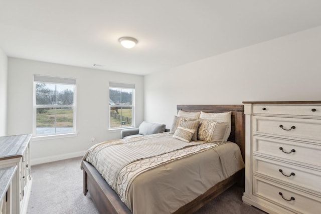 bedroom with baseboards, visible vents, and light colored carpet