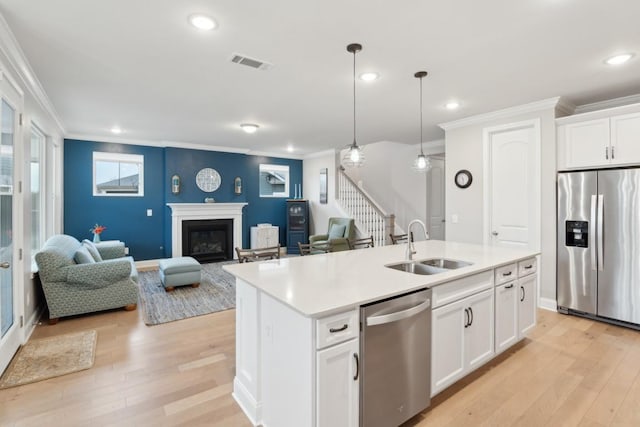 kitchen featuring visible vents, stainless steel appliances, a sink, and open floor plan