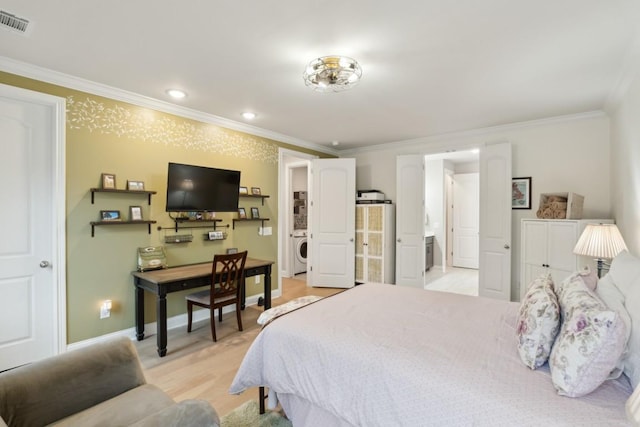 bedroom with crown molding, light wood finished floors, visible vents, washer / dryer, and baseboards