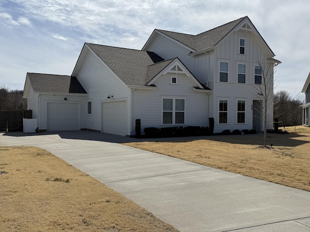 view of front facade with board and batten siding, a front lawn, roof with shingles, a garage, and driveway