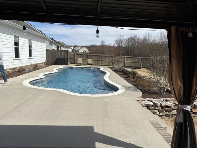 view of swimming pool with a fenced backyard, a fenced in pool, and a patio