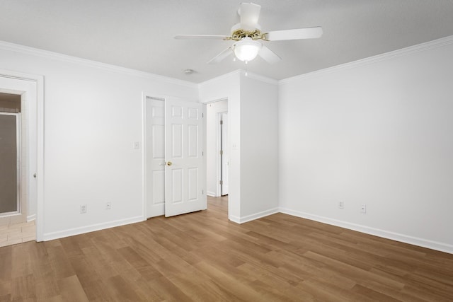 unfurnished bedroom with crown molding, baseboards, and wood finished floors