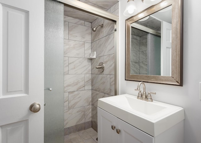 full bath featuring a tile shower and vanity