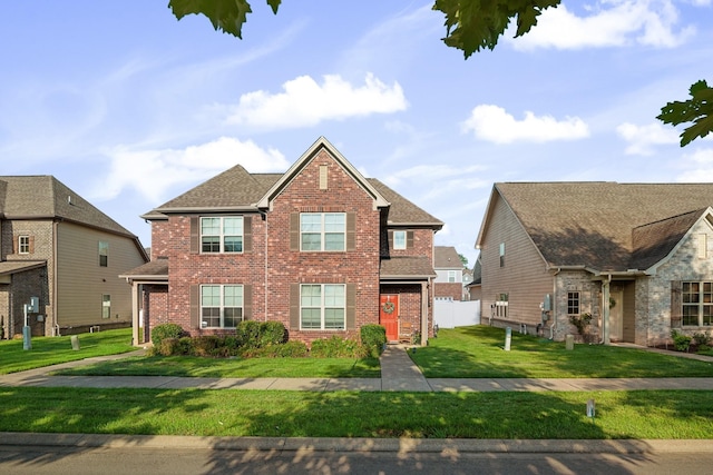 view of front of home with brick siding, a front lawn, and a shingled roof