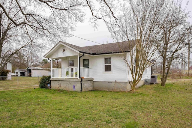 bungalow-style house with covered porch, a front yard, crawl space, central AC, and fence