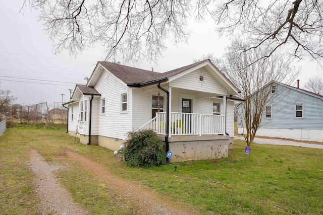 bungalow featuring a porch, driveway, crawl space, roof with shingles, and a front yard