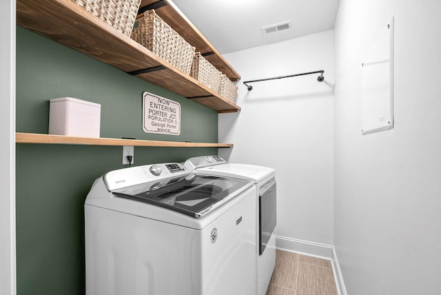 laundry room with laundry area, baseboards, visible vents, and washer and clothes dryer