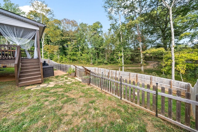 view of yard with a fenced backyard and a wooden deck