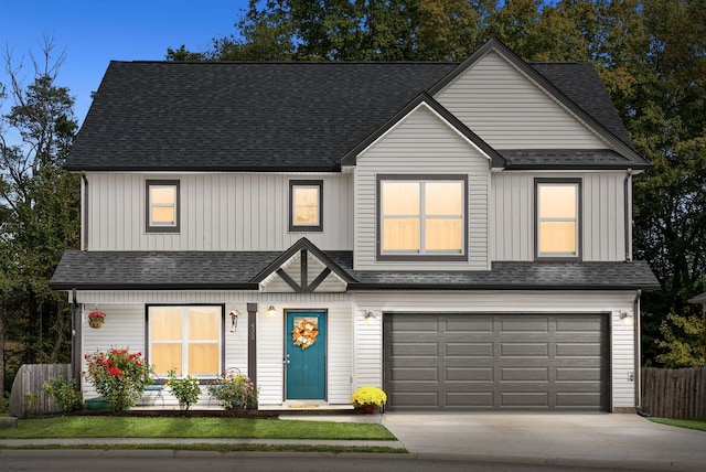 view of front of property featuring driveway, a shingled roof, and fence