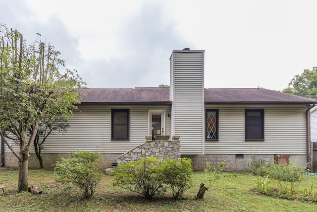 view of front facade with crawl space, roof with shingles, a chimney, and a front yard