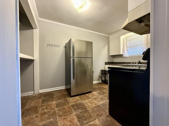 kitchen featuring baseboards, white cabinetry, crown molding, and freestanding refrigerator