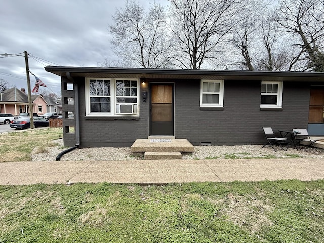 view of front of home featuring crawl space and brick siding