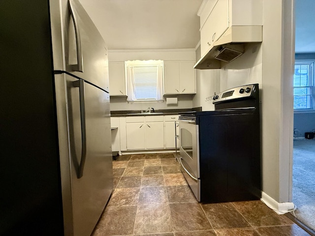 kitchen with dark countertops, appliances with stainless steel finishes, white cabinets, and a sink