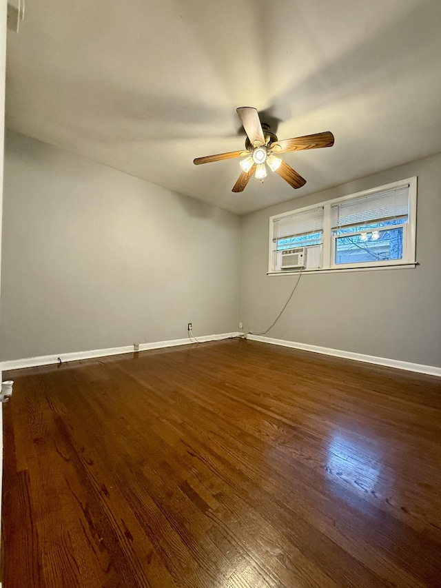 spare room with cooling unit, wood finished floors, a ceiling fan, and baseboards