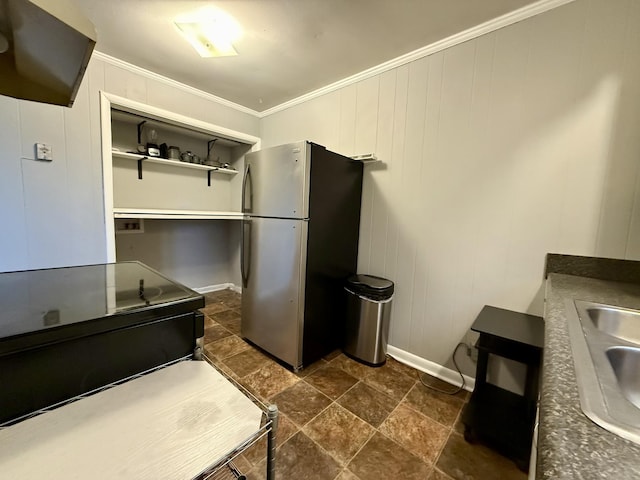 kitchen with a sink, baseboards, electric stove, ornamental molding, and freestanding refrigerator