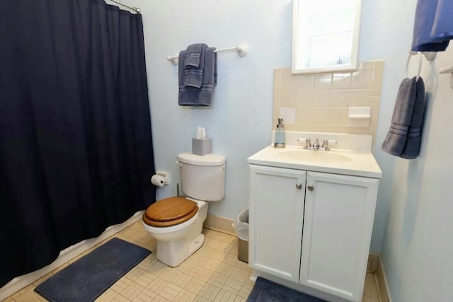 bathroom with baseboards, vanity, toilet, and a shower with curtain