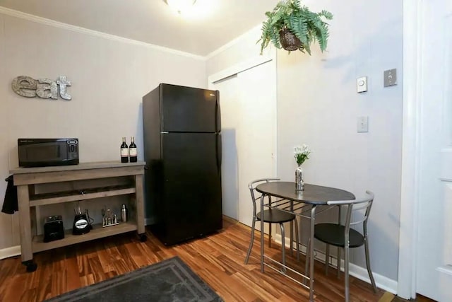 kitchen with black appliances, baseboards, ornamental molding, and wood finished floors