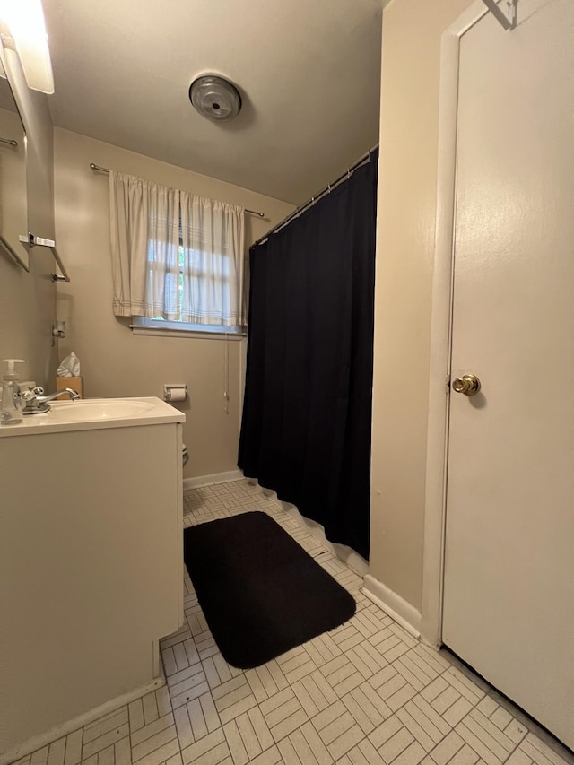 full bathroom with toilet, baseboards, a shower with shower curtain, and vanity