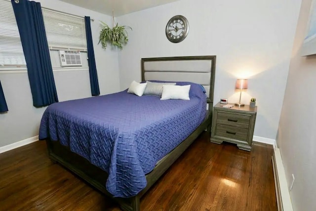 bedroom featuring baseboard heating, baseboards, and wood finished floors