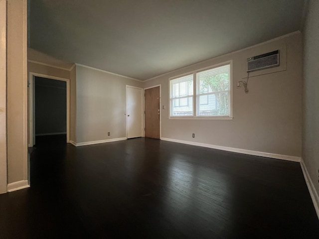 empty room featuring crown molding, a wall mounted air conditioner, dark wood-style floors, and baseboards