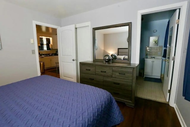 bedroom with ensuite bath and dark wood-type flooring