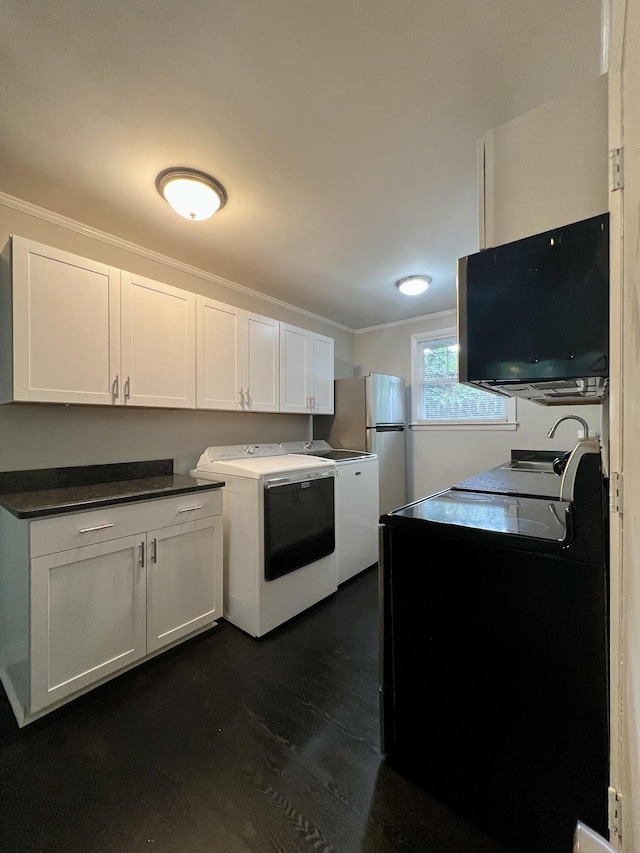 kitchen with separate washer and dryer, dark wood-style flooring, white cabinetry, ornamental molding, and dark countertops