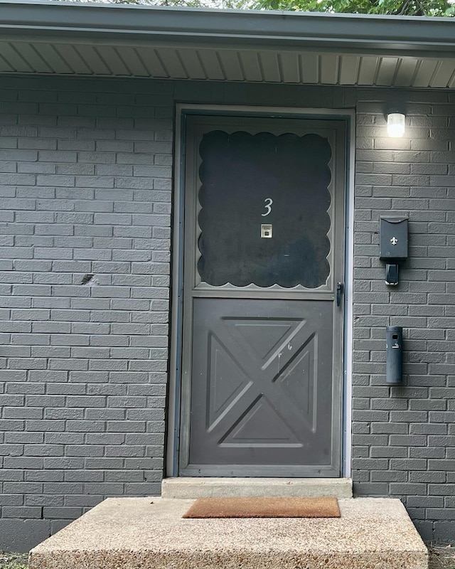 property entrance featuring brick siding