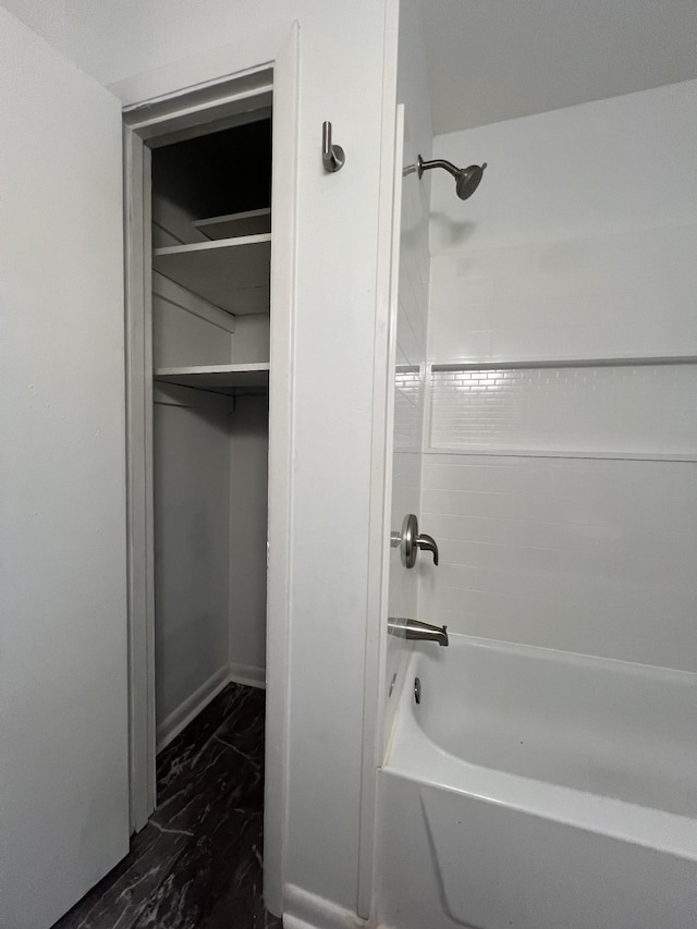 bathroom featuring marble finish floor and bathtub / shower combination