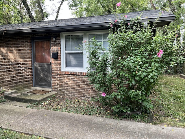 entrance to property featuring brick siding