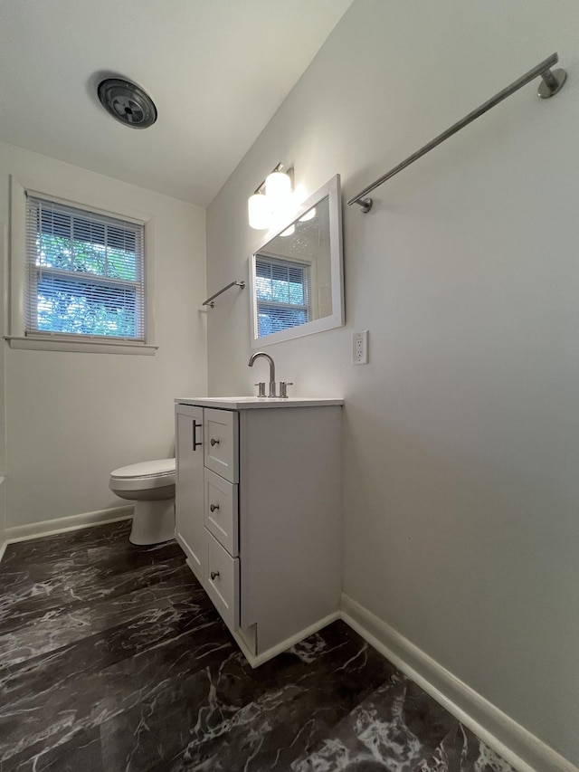 bathroom featuring marble finish floor, toilet, vanity, and baseboards